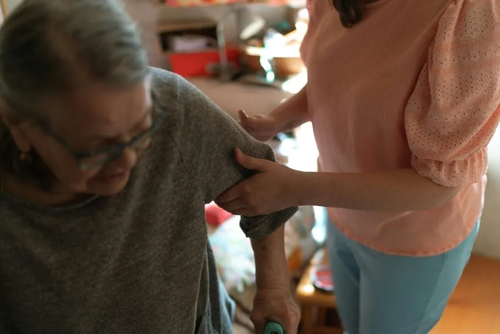 A caregiver helping an older woman at home