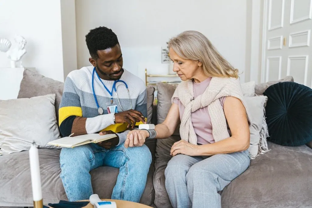 A home health nurse checking on an older patient