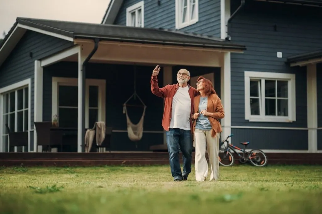 An older couple standing together outside their home