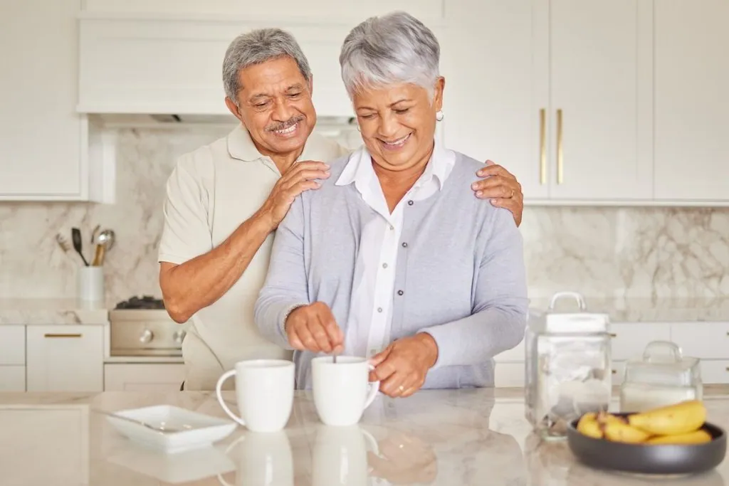 Two people smiling together in a kitchen